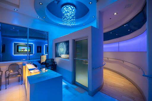 Modern clinical training studio with blue ambient lighting and advanced neuro-assessment equipment