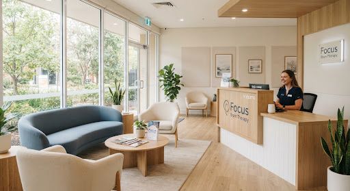 Bright, modern clinical reception area with light wood accents, soft blue and cream seating, and natural daylight